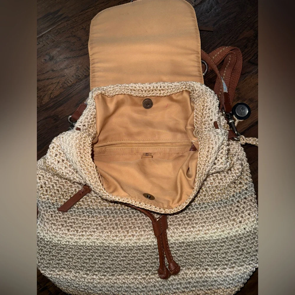 The Sak Crochet Straw Backpack in green and Cream with Brown Trim